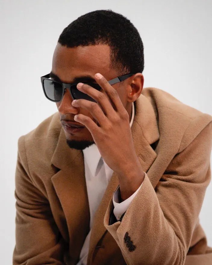 Vonté Smith — Camel coat and dark sunglasses, studio close-up