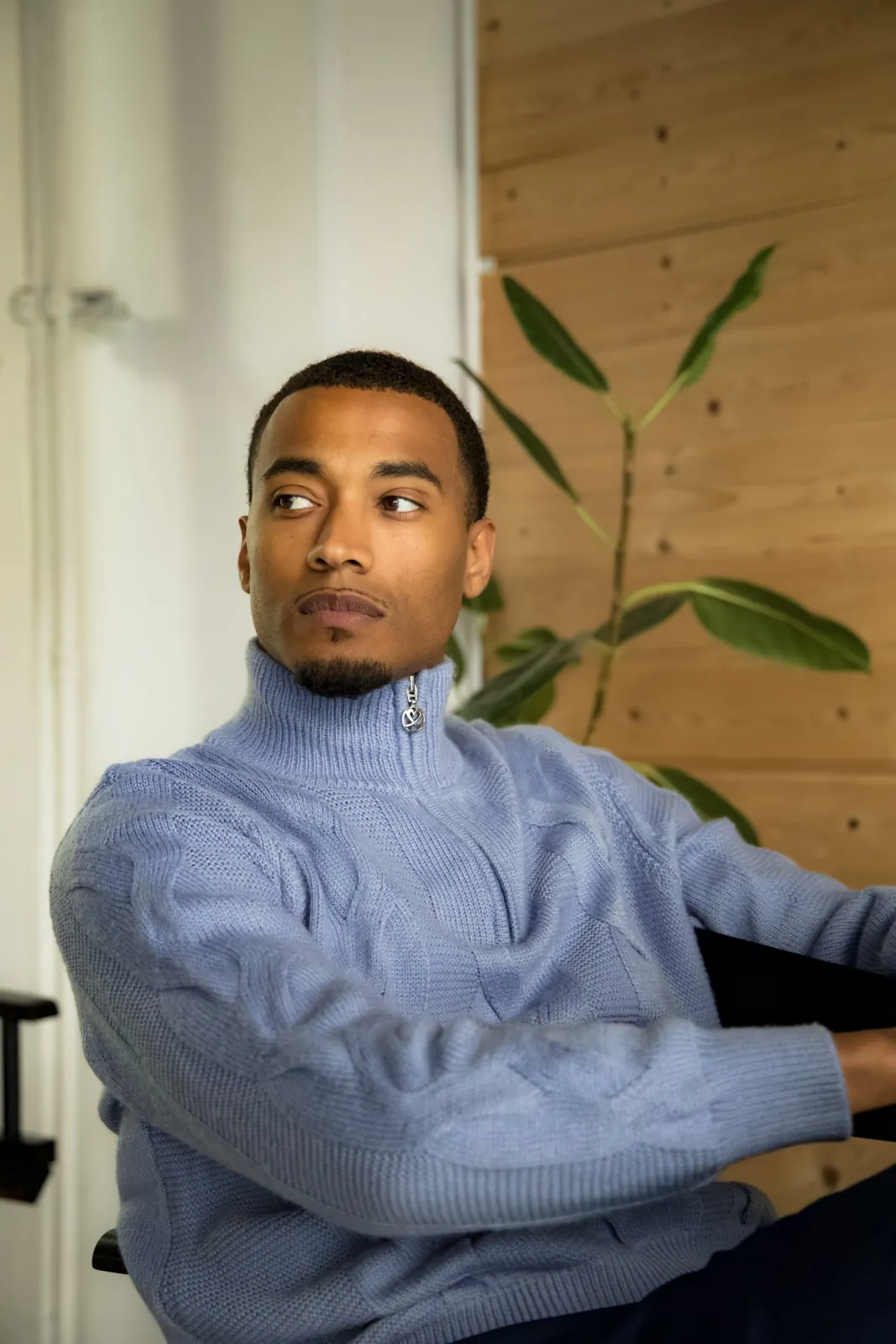 Vonté Smith in a blue knit quarter-zip, looking off camera