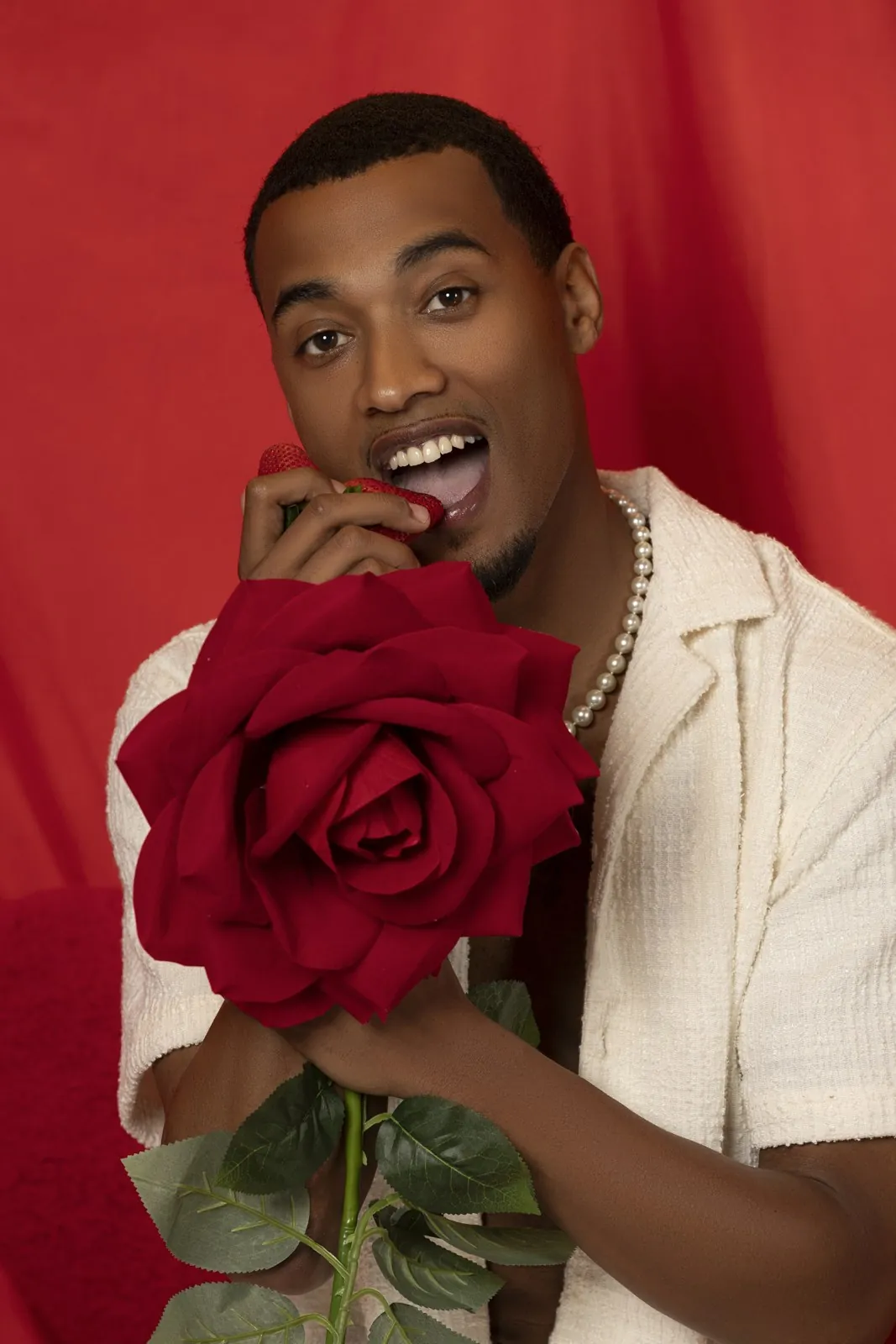 Vonté Smith — Holding a red rose against a red backdrop